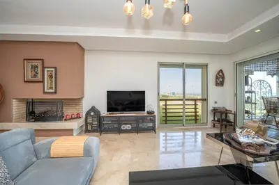 a living room with a couch and a tv at Seaside Luxury 3BR With Pool & Private Beach Access in Bouznika