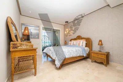 a bedroom with a bed and a table and a window at Seaside Luxury 3BR With Pool & Private Beach Access in Bouznika