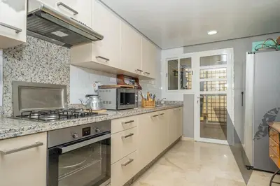 a kitchen with a stove and a refrigerator at Seaside Luxury 3BR With Pool & Private Beach Access in Bouznika