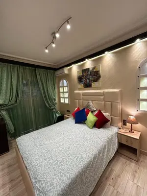a bedroom with a large bed with colorful pillows at Grand appartement romandie in Casablanca