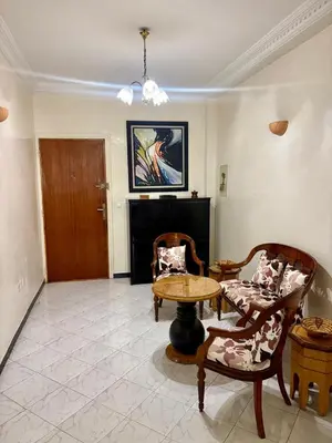 a living room with a table and two chairs at Appartement en plein cœur de Agdal in Rabat