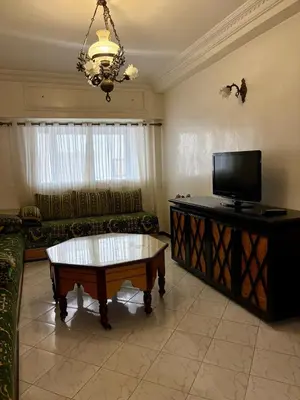 a living room with a couch and a tv at Appartement en plein cœur de Agdal in Rabat