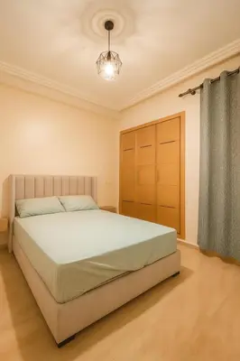a bedroom with a large bed and a closet at Appartement vue sur mer 3 chambres in Rabat
