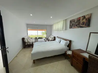 a bedroom with a bed and a living room at Maison Bord de Mer Skhirate in Skhirat