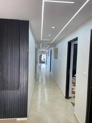a hallway with white walls and a wooden door at Maison Bord de Mer Skhirate in Skhirat