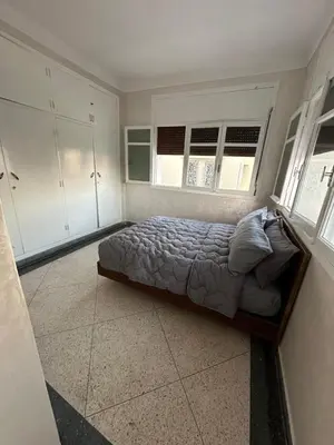 a bedroom with a bed in a room with windows at Villa Val d'Or in Temara