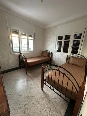 a bedroom with two beds and two windows at Villa Val d'Or in Temara