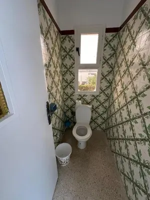 a small bathroom with a toilet and a window at Villa Val d'Or in Temara
