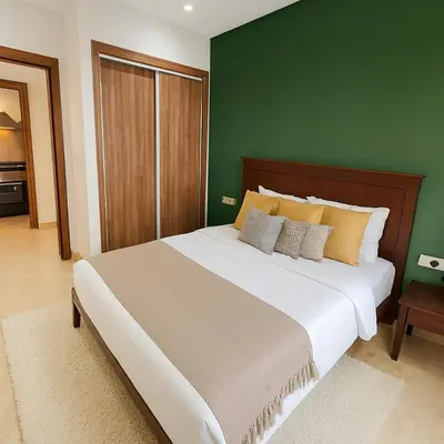 a bedroom with a large bed with a green wall at Cozy & Bright, Free Parking, Tram in Casablanca