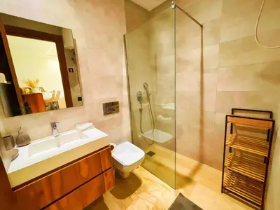 a bathroom with a shower and a toilet and a sink at Maya Suites - Oasis Casablanca in Casablanca
