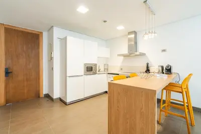 a kitchen with white cabinets and a wooden counter top at C08- Anfa Place Luxury Apartment - Beach Access in Casablanca