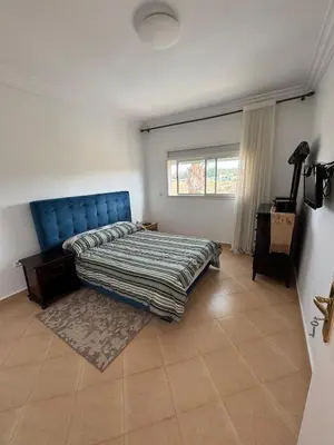 a bedroom with a bed with a blue headboard at Villa moderne en bord de mer in Skhirat