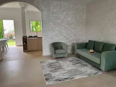 a living room with a green couch and a chair at Villa moderne en bord de mer in Skhirat