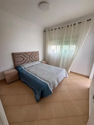 a bedroom with a bed with a blue blanket on it at Villa moderne en bord de mer in Skhirat