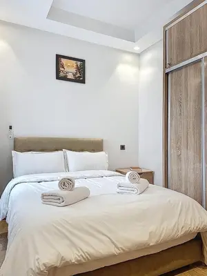 a white bedroom with a large bed with towels on it at Appartement Typique Marocain in Oulad Akkou