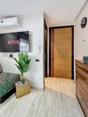 a bedroom with a bed and a television and a door at Appartement Typique Marocain in Oulad Akkou