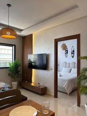 a bedroom with a bed and a tv on a wall at Cozy & Chill à 30min terrain de foot Netflix, AC pool & beach 2 min, in Bouznika