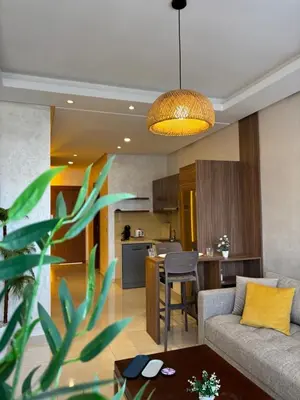 a living room with a couch and a table at Cozy & Chill à 30min terrain de foot Netflix, AC pool & beach 2 min, in Bouznika