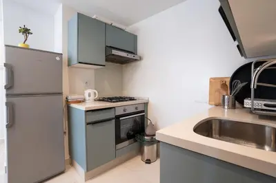 a small kitchen with a refrigerator and a sink at C14- 1BR Luxury Apartment -Terrace Majorelle in Casablanca