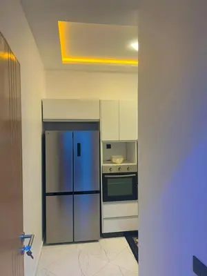 a kitchen with a refrigerator and a stove at Appartement chic a 5 mins de la plage in El Harhoura