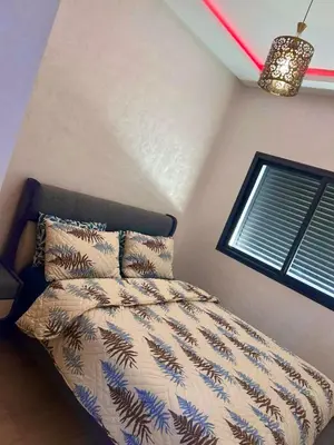 a bedroom with a bed and a window at Appartement chic a 5 mins de la plage in El Harhoura
