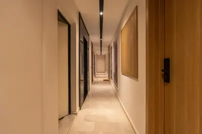 a hallway with white walls and a long hallway with paintings at C13 - 1BR Suite - Private Gym - Terrace - Rooftop in Maarif