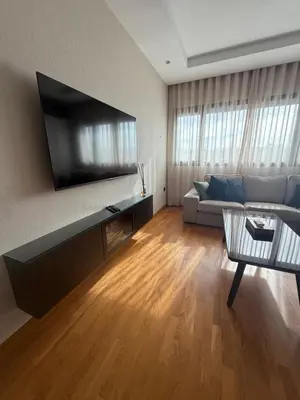 a living room with a couch and a flat screen tv at Marina, Medina et Bab Marrakech 8 min Hassan 2 in Casablanca