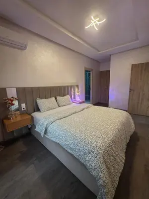 a bedroom with a large bed with a light on it at Appartement in Casablanca
