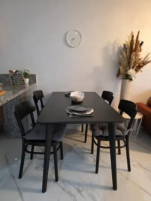 a black dining table and chairs in a living room at Appartement in Casablanca