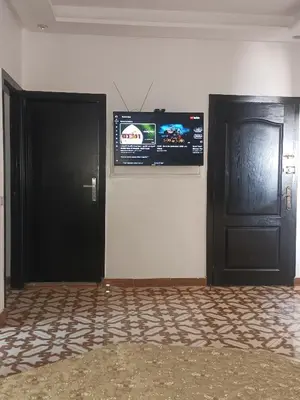 a room with two doors and a television on the wall at Appartement temara in Temara