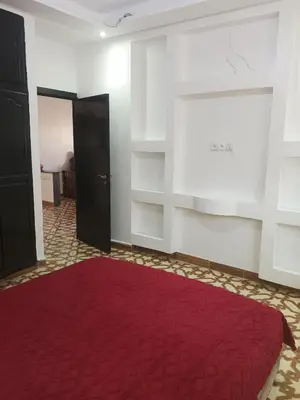 a room with a red rug and a window and a door at Appartement temara in Temara