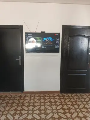 a room with two doors and a television on the wall at Appartement temara in Temara