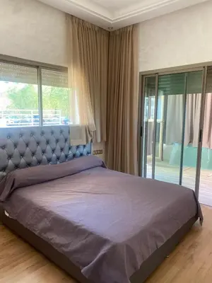 a bedroom with a large bed with a large window at New ground floor apartment - Large terrace direct access to pool in Bouznika