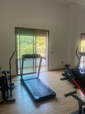 a room with a gym with several exercise bikes at New ground floor apartment - Large terrace direct access to pool in Bouznika