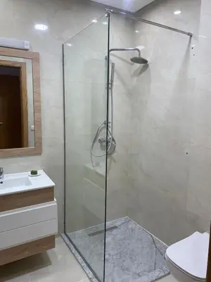 a bathroom with a shower and a toilet and a sink at New ground floor apartment - Large terrace direct access to pool in Bouznika