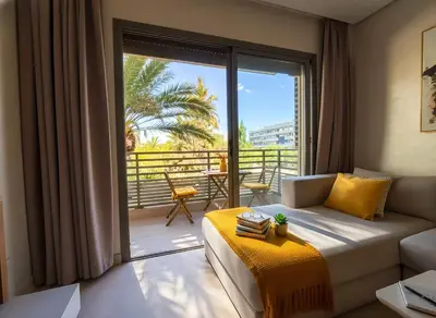 a living room with a couch and a balcony at Maya Suites - Riviera B Casablanca in Casablanca