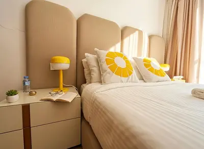 a bedroom with a bed with a headboard and a table at Maya Suites - Riviera B Casablanca in Casablanca