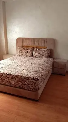 a bed in a bedroom with a wooden floor at Apartment kamal park F1 in Mohammedia
