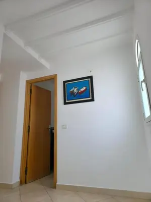 a hallway with a painting on a wall at Beach & Art Bungalow in El Harhoura
