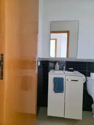 a bathroom with a sink and a toilet and a mirror at Beach & Art Bungalow in El Harhoura