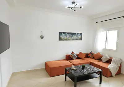 a living room with a couch and a table at Beach & Art Bungalow in El Harhoura