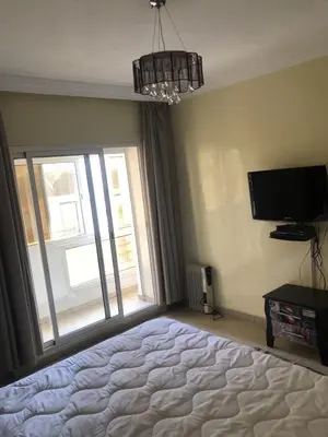 a bedroom with a bed and a tv and a window at Central Casablanca Apartment Steps from Hassan II Area in Casablanca