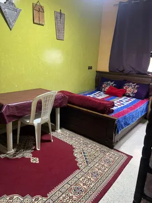 a bedroom with a bed and a table and a chair at Naima in Rabat