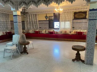 a large room with a red couch and chairs at Naima in Rabat