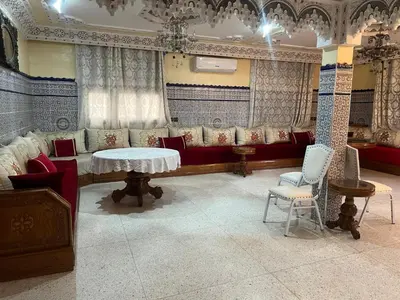 a room with a couch and a table and chairs at Naima in Rabat