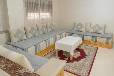 a living room with two couches and a table at Spacieux RDC avec salle de sport privative in Bouznika