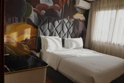 a bedroom with a bed with a painting on the wall at Modern Studio with Rooftop Pool & Free Parking in Casablanca