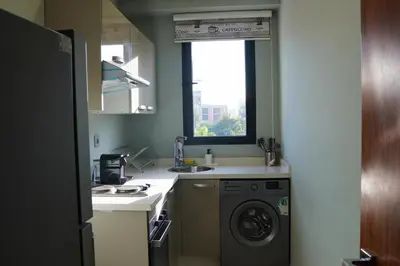 a kitchen with a washing machine and a window at Modern Studio with Rooftop Pool & Free Parking in Casablanca