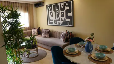 a living room with a couch and a table at Modern Studio with Rooftop Pool & Free Parking in Casablanca