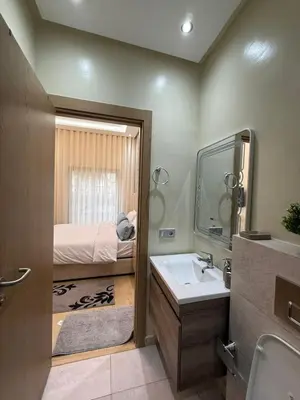 a bathroom with a sink and a bedroom with a bed at Appartement 3 chambres avec piscine, proche de la plage Zenâta Eco City in Aïn Harrouda